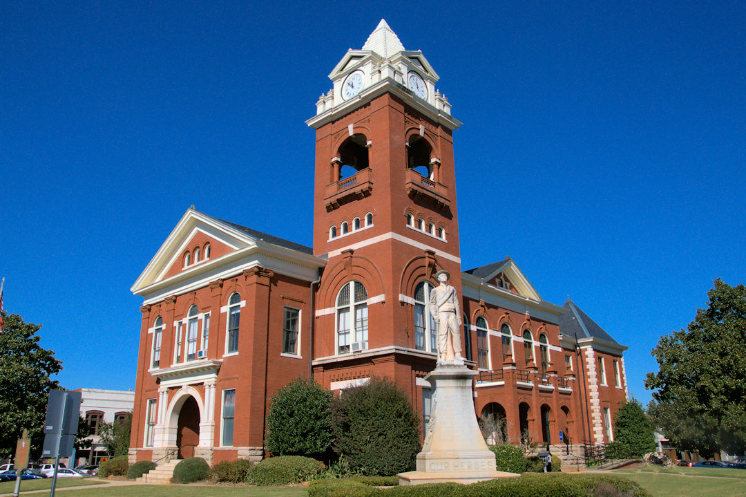 The historic Butts County Courthouse with its red-brick clock tower on the square in downtown Jackson, Georgia, under a clear blue sky